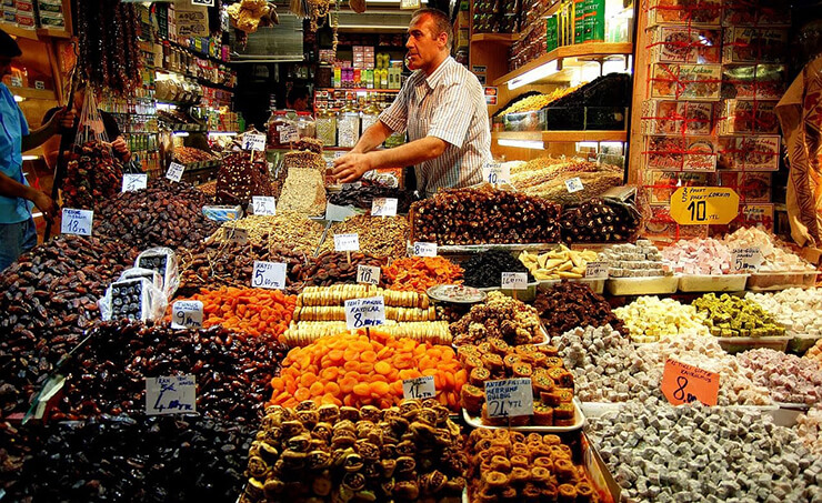 La ciudad de Turquía es sinónimo de compras y especialmente Estambul. En ella podemos encontrar modernos centros comerciales en los cuales existen una gran variedad de objetos, prendas y accesorios de último modelo en moda tanto nacional como internacional. También podemos ubicar en la ciudad los antiguos bazares con alfombras, bisutería, kilims, piedras preciosas, cerámica, telas de seda, cuero, adornos, objetos en cobre, plata, además de especias, café turco, té y demás. Todo lo mencionado anteriormente generalmente lo encontraremos en los bazares de las grandes ciudades PRODUCTOS TÍPICOS Uno de los artículos bandera de Turquía son sus alfombras muchos turistas, la gran mayoría los adquieren de recuerdo como visita de la ciudad, cabe destacar que los encontraran de todos los tipos, tamaños, colores, calidades, precios y generalmente en los bazares, mercados y tiendas suntuosas. Le recomendamos en todo caso solicitar siempre un recibo que le garantice pasar sin dificultad por la aduana en su viaje de retorno. A pesar que la mayoría de objetos que se venden como antigüedades suelen ser falsos, los turistas igual tienden a comprarlos, pero hay que tener en cuenta que en Turquía está prohibida la exportación de tales artículos, por lo que en caso adquiera un objeto de más de cien años, necesitará de todas maneras una licencia emitida por el Museo Provincial, lo cual es muchas veces un trámite tedioso de realizar. Los Baklavas son postres típicos de este país, en Estambul los encontrará en todos los estilos y sabores, ya sea con nueces, pistachos, almendras, en fin, una variedad. Uno de estos postres envuelto con mucha delicadeza puede ser el obsequio perfecto para sus familiares y amigos, no suelen ser muy caros y puede comprarlos en cualquier parte de la ciudad. La ciudad de Estambul se la conoce también por las falsificaciones de artículos de marcas de calidad, tanta ropa, relojes, zapatos, carteras que se expenden en varios lugares, en especial en zonas cercanas al Gran Bazar, un verdadero paraíso donde nadie interferirá se exhiba con naturalidad. De manera general, en los bazares y mercados podrá encontrar una gran variedad de productos de todo tipo, hermosos, pintorescos fuera de lo común. Algunos turistas prefieren comprar té, especias, frutos secos, productos que forman sabores tradicionales turcos; por el contrario, hay turistas que se inclinan por artículos exóticos como lámparas, pipas de narguile, etc. Sea cual sea su preferencia no olvide llevarse también uno de los típicos ojos turcos (nazar boncugu) un símbolo distintivo de nuestro país que según se indica lo protegerá contra las malas miradas. BAZARES DE ESTAMBUL En cuanto a Bazares donde encontrará de todo y para todos, una gran variedad de artículos y productos, podemos mencionar que existen dos grandes e importantes que acaparan la mayor atención y generan el mayor número de visitas que casi casi son verdaderas atracciones turísticas.